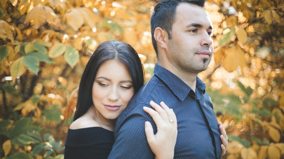 Women holding man from behind.